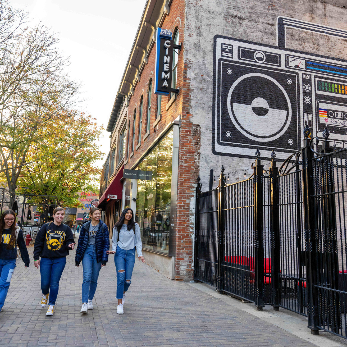 People wearing University of Iowa clothing walking down a street